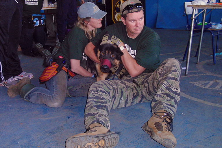 Ron Presley, with Tracie Dawson, holds a traumatized dog rescued after Chile Earthquake. (c) Kinship Circle