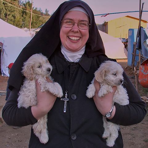 Sister Michael Marie, Kinship Circle Public Information and Staff Relations Officer, in Chile at an earthquake tent camp for displaced people with animals who need food and vet care. (c) Kinship Circle
