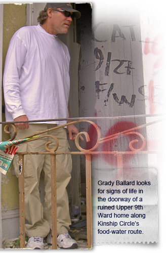Grady Ballard looks for signs of life in the doorway of a ruined Upper 9th Ward home 330x500