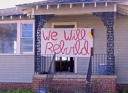 A poster nailed to a Katrina destroyed home in Lakeview says We Will Rebuild 422x306