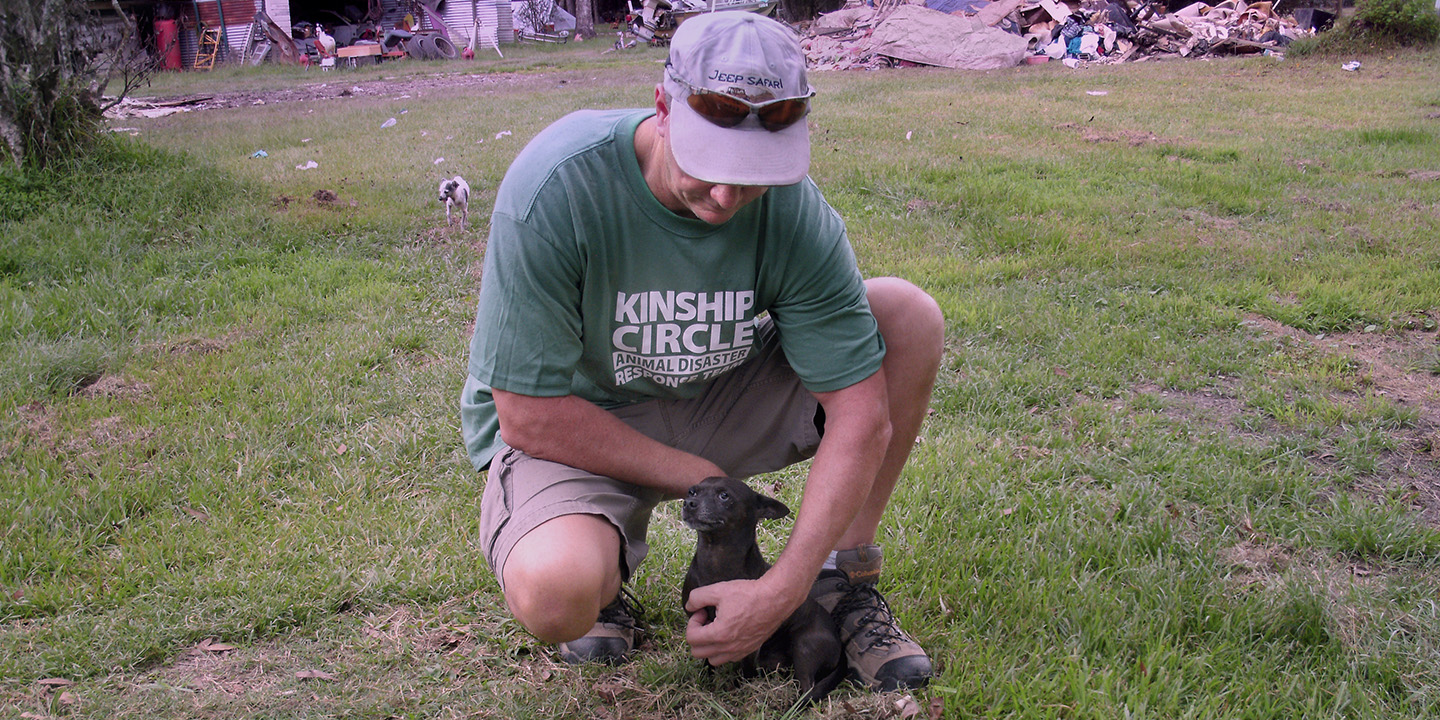 In Colyell, a deeply flooded part of Livingston Parish, Louisiana, animals are left behind. And they're very hungry. Ron Presley soothes Butterbean the Chihauhaua. (c) Kinship Circle, Chile Earthquake