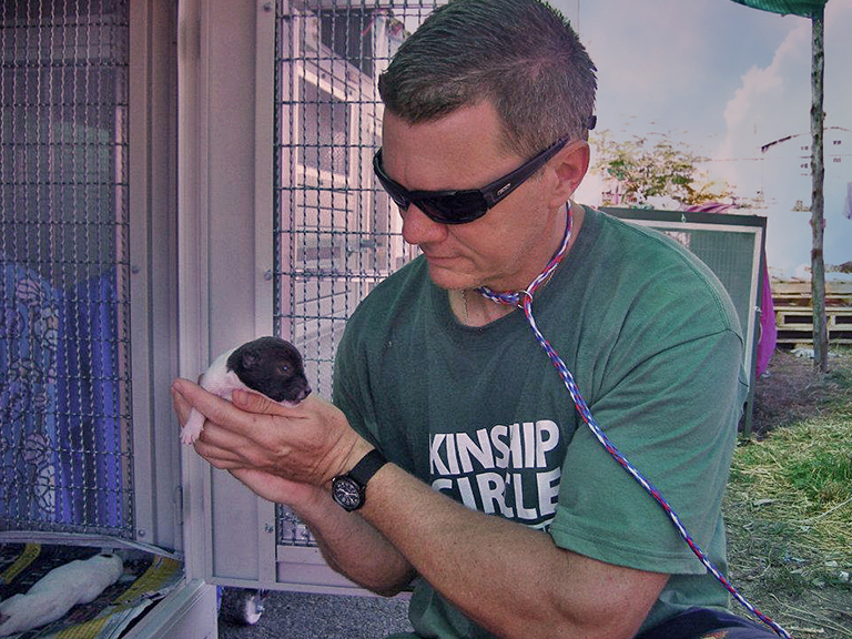 Ron Presley cradles a tiny newborn at the Bang Pu emergency shelter in Bangkok. (c) Kinship Circle, Thailand Floods