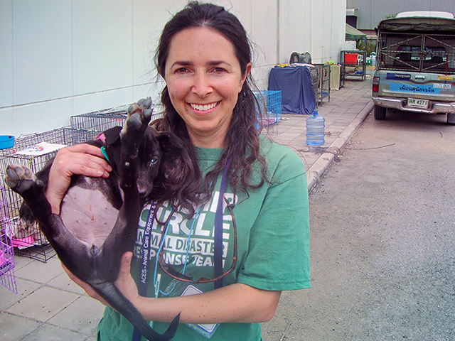 Stephanie plays with a flood pup (c) Kinship Circle